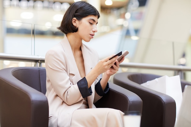 Mooie vrouw met behulp van mobiele app in mall