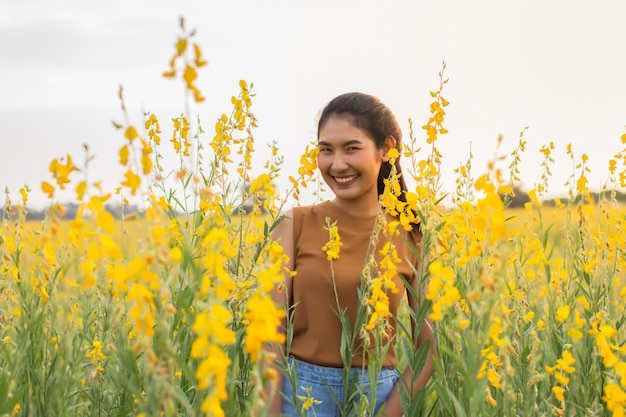 Mooie vrouw met bloemcrotalaria tijdens de avond