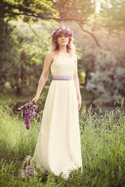 Mooie vrouw met bloemen buiten op groen gras achtergrond in romantische lentedag