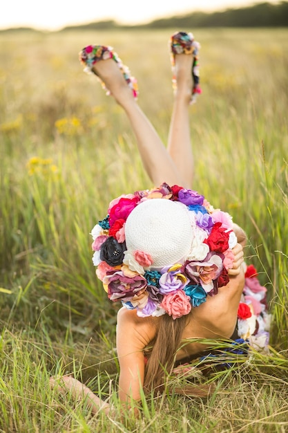 Mooie vrouw met bloemenjurk en hoed buitenshuis