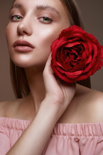 Mooie vrouw met bloemenmeisje met make-up en roos