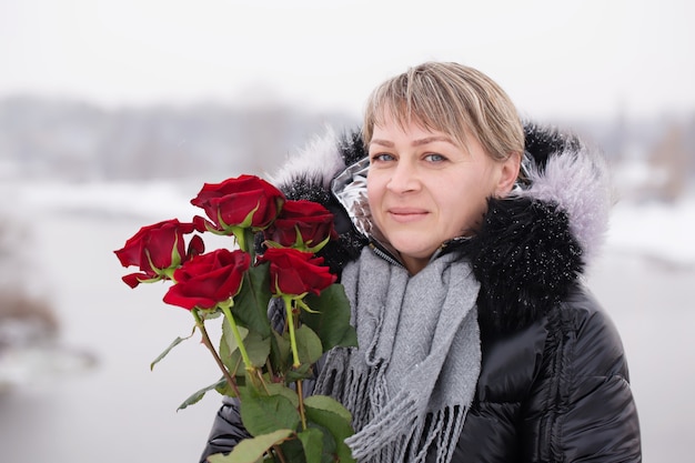 Mooie vrouw met boeket van rode rozen op valentijnsdag