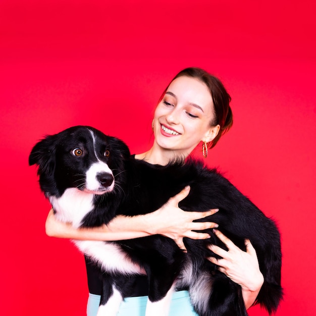 Mooie vrouw met border collie in studio gele en rode achtergrond