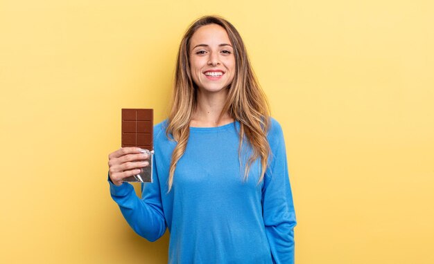 mooie vrouw met chocolade tegen geïsoleerde muur