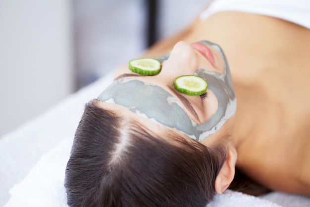 Mooie vrouw met cosmetisch masker op gezicht