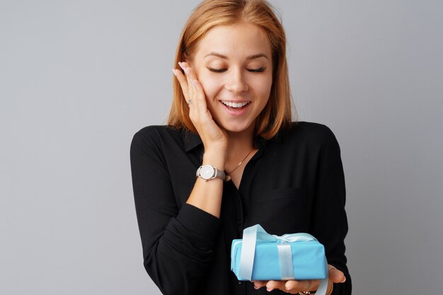 Mooie vrouw met een blauwe geschenkdoos in haar handen