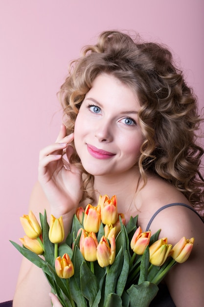 Mooie vrouw met een boeket van gele tulpen.