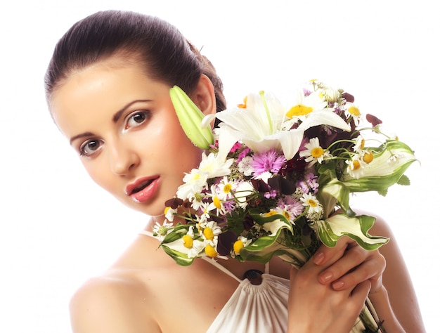 Mooie vrouw met een boeket van verschillende bloemen