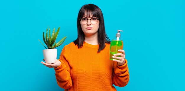 Mooie vrouw met een grote maat die cactus vasthoudt