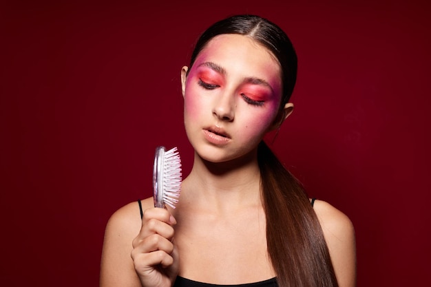 Mooie vrouw met een kam in de hand lichte make-up poseren mode emoties studio model