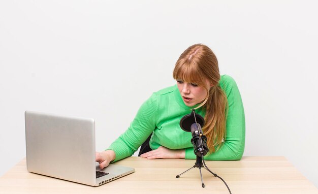 mooie vrouw met een laptop en een microfoon sociaal netwerk freelance concept