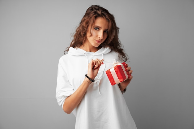 Mooie vrouw met een rode geschenkdoos in haar handen