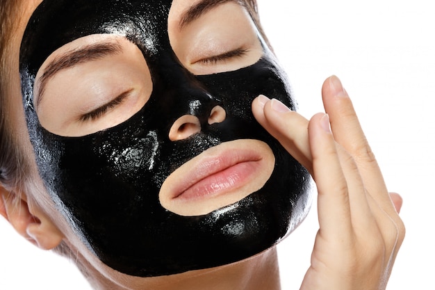 Mooie vrouw met een zuiverend zwart masker op haar gezicht