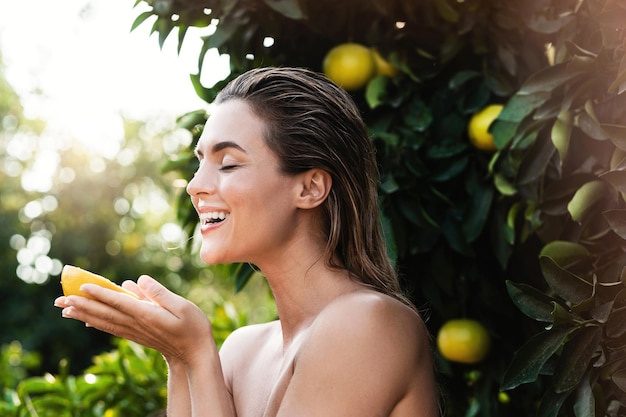 Mooie vrouw met gladde huid met een citroenfruit in haar handen