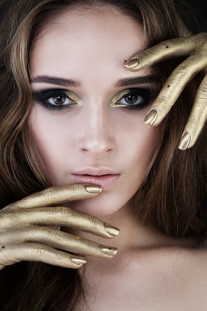 Mooie vrouw met gouden make-up