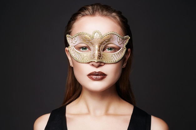 Mooie vrouw met gouden masker