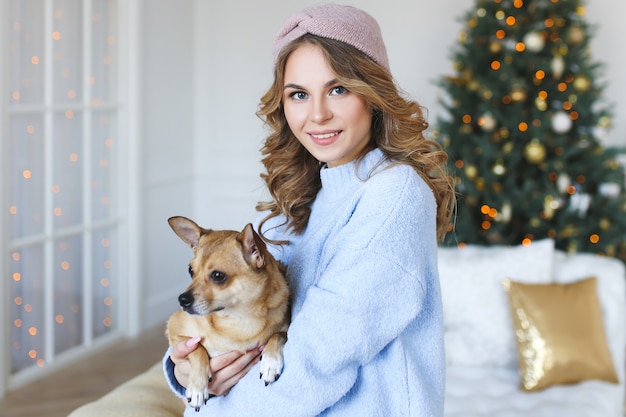 Mooie vrouw met hond op kerstmis thuis