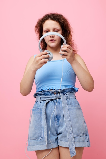 Mooie vrouw met koptelefoon afleiding mode dans roze achtergrond ongewijzigd