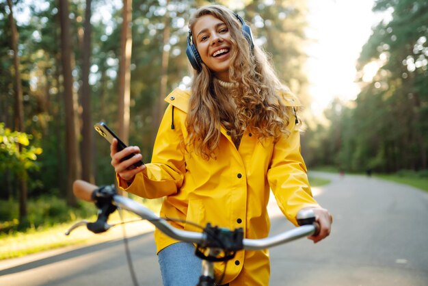 Mooie vrouw met koptelefoon en smartphone rijdt op de fiets luisteren naar muziek Actieve levensstijl