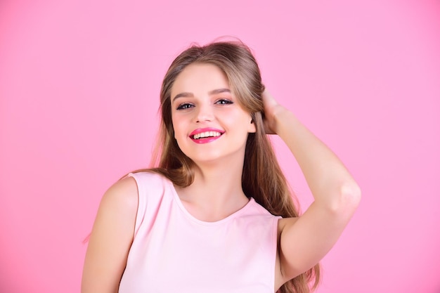 Mooie vrouw met lang haar poseren op roze achtergrond