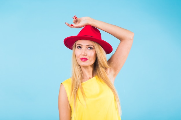 Mooie vrouw met lang recht blond haar. Mannequin poseren op blauwe muur