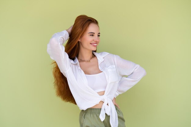 Mooie vrouw met lang rood haar in casual shirt op groene achtergrond positief lachend lachen genietend van verlaten