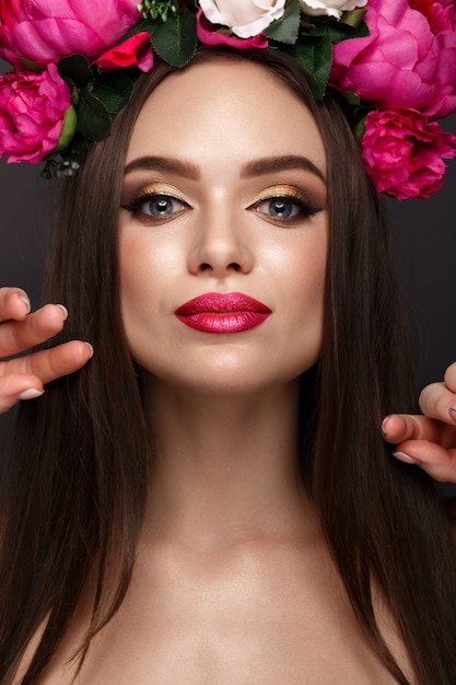 Mooie vrouw met lichte make-up en bloemen op haar hoofd