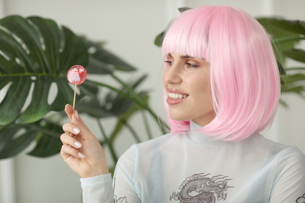 Mooie vrouw met mode kapsel en lolly Roze haar