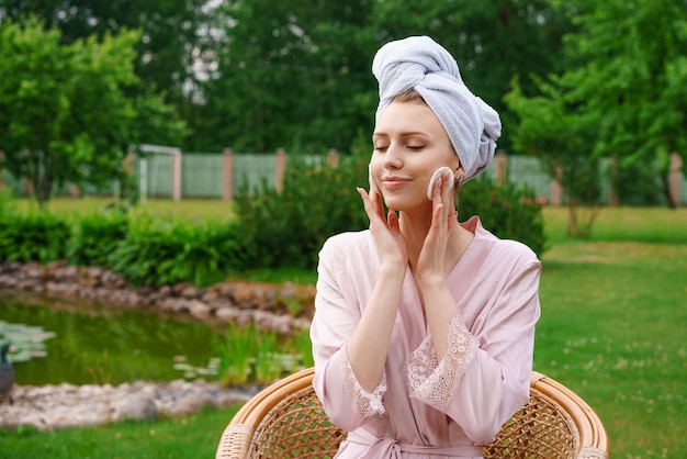 Mooie vrouw met perfecte huid die make-up doet en de huid op haar gezicht reinigt