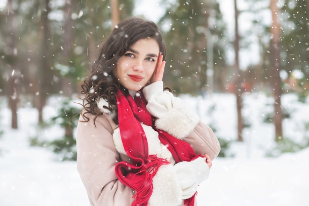 Mooie vrouw met rode lippenstift poseren bij sneeuwweer. Lege ruimte