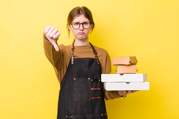 Mooie vrouw met rood hoofd die zich kruiselings voelt duimen naar beneden fast food take away tender