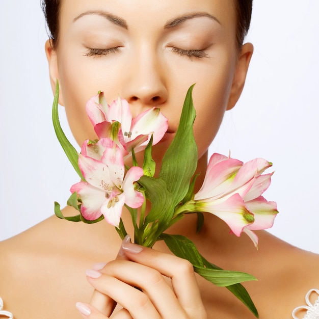 Mooie vrouw met roze bloem