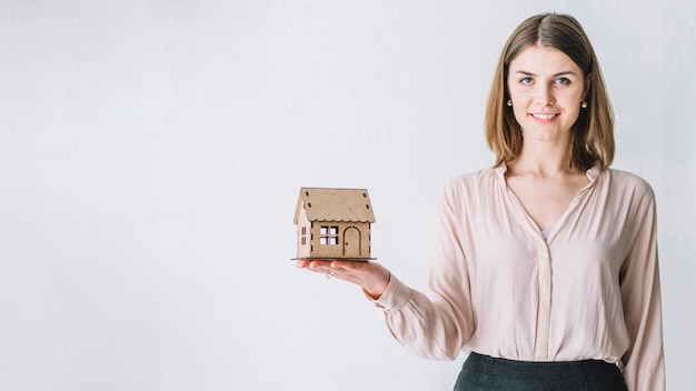 Mooie vrouw met speelgoed huis