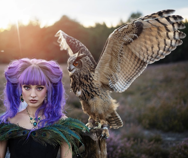 Foto mooie vrouw met uil in de natuur