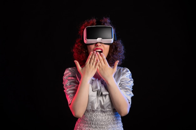 Mooie vrouw met virtual reality headset op donkere ondergrond