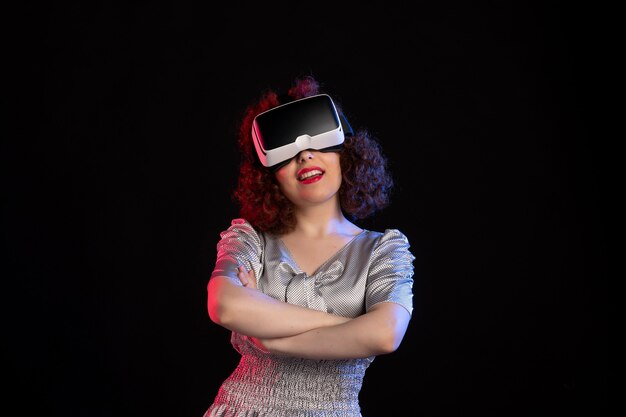 Mooie vrouw met virtual reality headset op donkere ondergrond