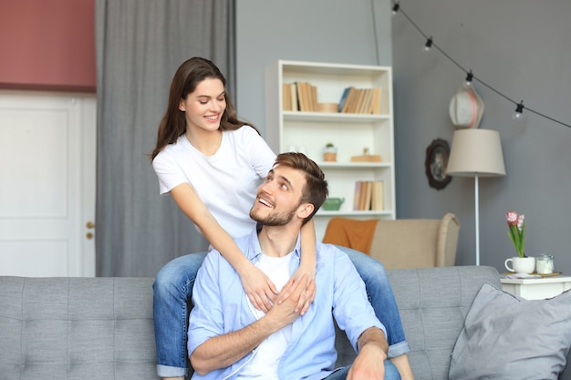 Mooie vrouw met vriendje quality time samen doorbrengen op de bank thuis in de woonkamer.