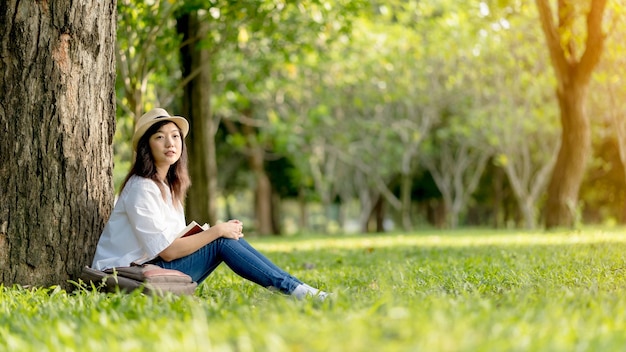 Mooie vrouw met wit overhemd en witte hoed Genieten van een boek lezen en ontspanning