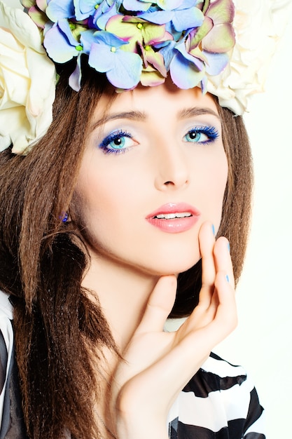 Mooie vrouw. Mode make-up. Kapsel met bloemen