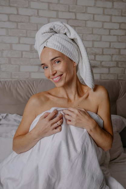 Mooie vrouw na een douche met een handdoek op haar hoofd