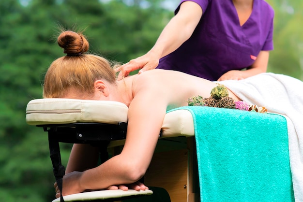 Mooie vrouw ontspant op massagetafel therapeut masseur doet professionele massage