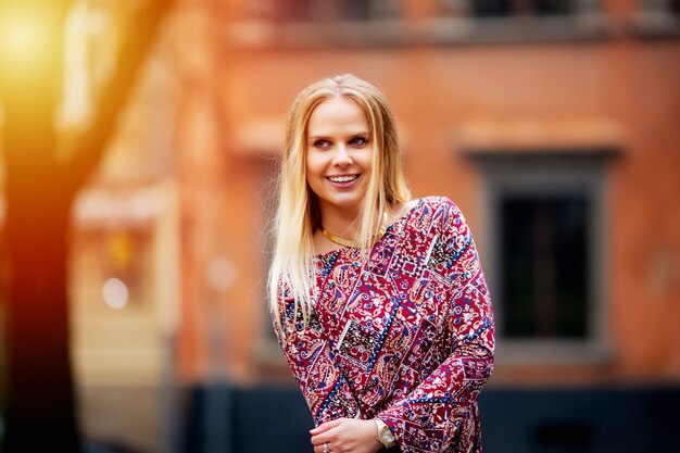 Mooie vrouw op de achtergrond van huizen glimlachen