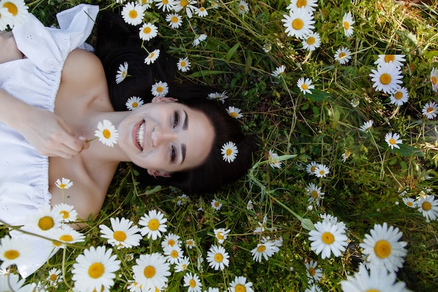 Mooie vrouw op een bloem granden die in openlucht van haar tijd geniet