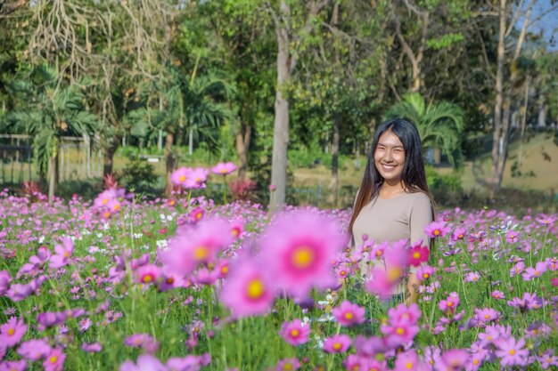 Mooie vrouw op een gebied van bloemenkosmos