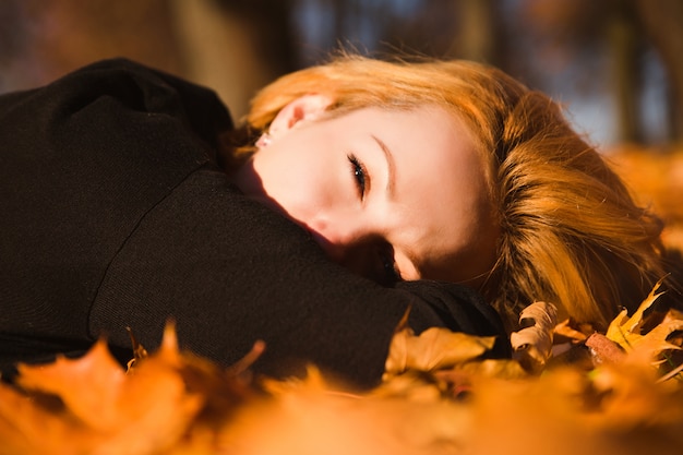 Mooie vrouw op herfstbladeren