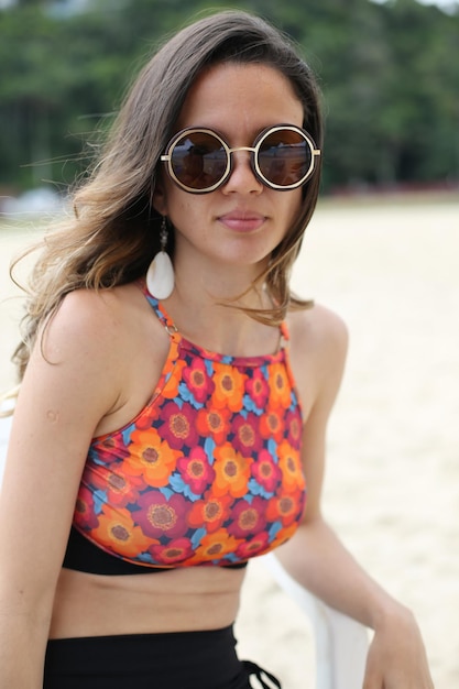Mooie vrouw op het strand met zwarte zonnebril met mooie achtergrond