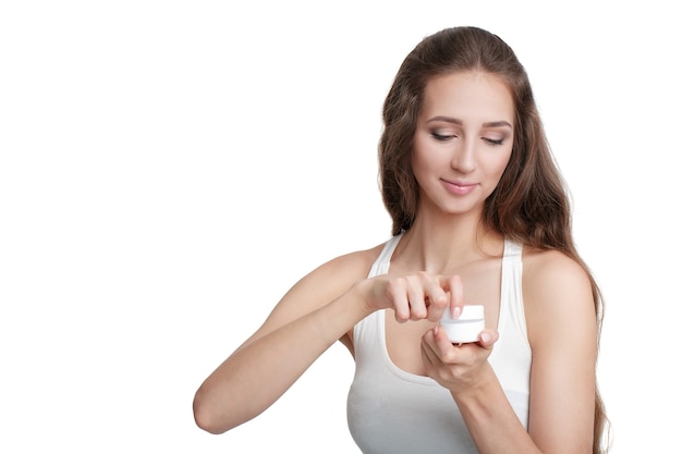 Mooie vrouw open pot cosmetische crème geïsoleerd op een witte achtergrond