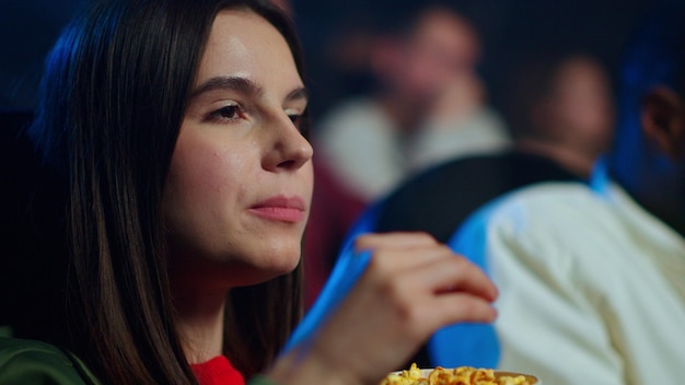 Mooie vrouw popcorn eten in de bioscoop Aantrekkelijk meisje kijken naar film