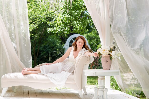 Mooie vrouw poseren in de zomertuin