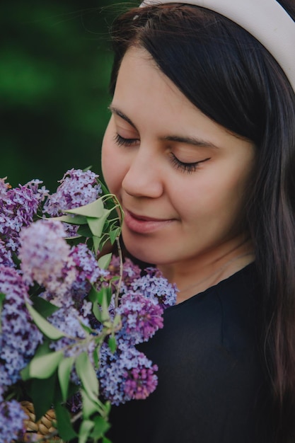 Mooie vrouw poseren met lila bloemen de zomer komt eraan